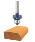 Real Badass 1/8 Inch Radius Roundover Router Bit With Two Flute Micrograin Carbide Cutting Edges and Compact Ball Bearing Guide for Slick Woodworking Projects and No Mess Finishes above a rounded wooden edge.