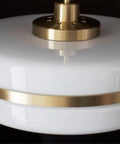 Close-up of Sleek Gold Glass Pendant Light, Modern Circular Hanging Lamp with white glass shade and gold accent detail.