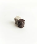 Stack of brown and beige 1-Inch Square Self-Stick Furniture Sliders For Carpet Protect Your Furniture And Move Effortlessly