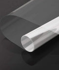 Clear Window Security Film Adhesive 2 Mil Anti Shatter UV Blocking Shield for Home and Office roll close-up on dark background