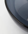 Close-up of the Dope Gray Round Glass Vessel Sink With Waterfall Faucet And Pop Up Drain Above Counter Bathroom Vanity Basin