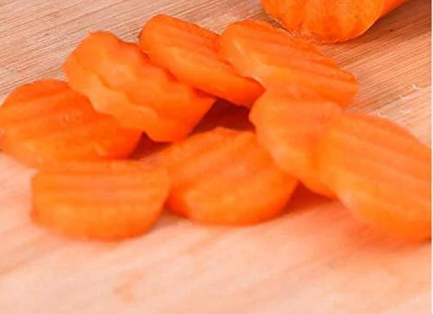 Orange crinkle-cut carrot slices on a wooden cutting board.