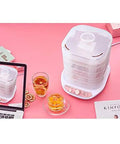 Slick Digital Food Dehydrator Featuring Five Stackable Trays Adjustable Heat Control Plus Solid Forty Eight Hour Timer on a pink table.