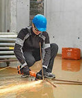 Person using the Beast Mode 18V Cordless Angle Grinder for cutting metal on a construction site, wearing safety gear.