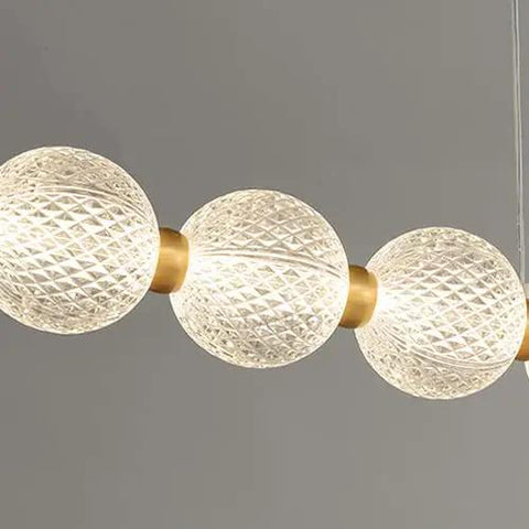 Modern Minimalist Magic Bean Chandelier With Nine Slick Brass Pendant Lights Adding Instant Vibe To Cool Cafes And Lounges While Delivering Top Notch Durability showcasing three elegant glass globes.
