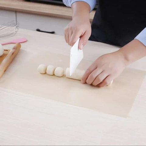 Person using Five Pack Teflon Baking Sheets 12x16 Inch Nonstick Reusable Liners to mold dough, showcasing versatility for DIY projects.