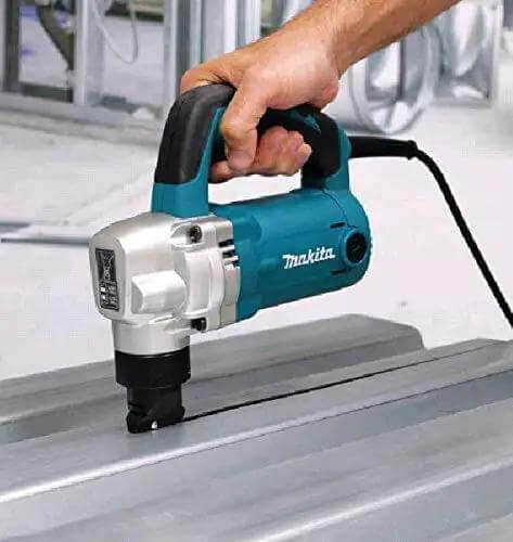 Person using the Powerful 710W Nibbler With 3.2 mm Capacity, Soft Grip Ergonomic Handle on sheet metal, emphasizing chip clearance.