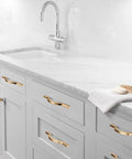 Golden Wave Shaped Cabinet Pulls Set Of 6 With Glossy Cupboard Drawer Knobs installed on white kitchen cabinets.