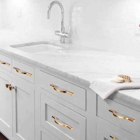 Golden Wave Shaped Cabinet Pulls Set Of 6 With Glossy Cupboard Drawer Knobs installed on white kitchen cabinets.