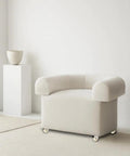 Modern beige armchair on casters in minimalist room with white decor