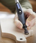 Close-up of Dremel flex shaft rotary tool with comfort grip used on a light wood workpiece