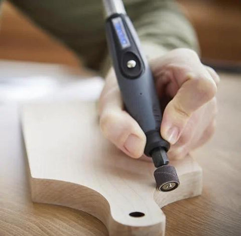 Close-up of Dremel flex shaft rotary tool with comfort grip used on a light wood workpiece