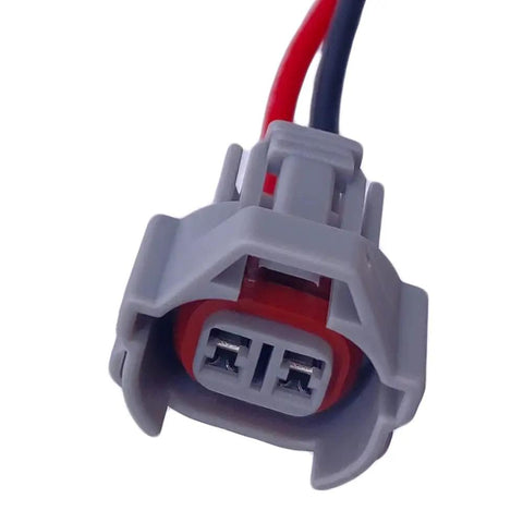 Close-up of a gray electrical plug from a Four Piece Fuel Injector Connector Kit Plug And Play Quick Disconnect Pigtails.
