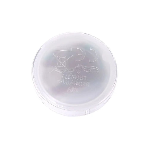 Close-up of a clear round plastic watch back cover with embossed 12V and battery-type markings