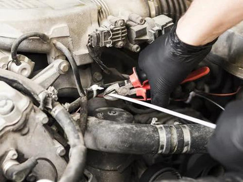 Black nitrile disposable gloves worn by a mechanic while working on a car engine