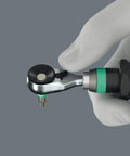 Hand holding Zyklop Mini 4 Bit Ratchet One Quarter Inch Drive Fifty Millimeter Hex Bit Holder with thumbwheel visible.