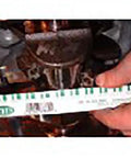 Plastigage strip, green, for engine bearing clearance, shown beside a tape measure.
