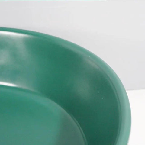 Close-up of the dark green surface of a Bathroom Sink Bathroom Round Non-Porous Ceramic Wash Basin.