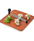 Anjali Fantastique Deluxe stainless steel vegetable cutter on wooden board with sliced mushrooms and peppers.