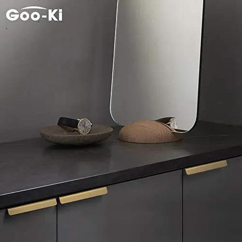 Top Shelf Pure Brass Finger Pulls With Brushed Matte Finish Hella Slim Modern Cabinet Handles Five Inch Center To Center Six Pack Rock Solid Hardware For A Slick Home Refresh on dark cabinet surface.