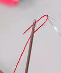Close-up of needle threading using 5 Piece Needle Threading Tool Set For Sewing Beading And Crafting Easy Threading Guides Durable Plastic Threaders