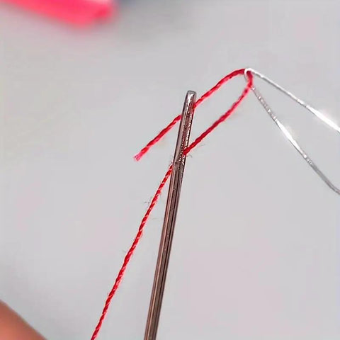 Close-up of needle threading using 5 Piece Needle Threading Tool Set For Sewing Beading And Crafting Easy Threading Guides Durable Plastic Threaders