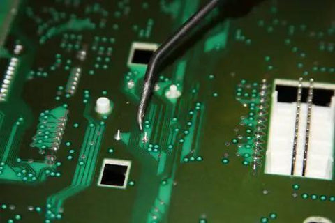Close-up of circuit board with soldering tool, part of Six Piece Stepper Motor Repair Kit X27.168 For Chevy GM GMC Dash Gauges 2003 2006