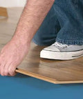 Person installing Top Tier Floating Floor Underlayment 200 Square Foot Roll with 3Mm Density under laminate flooring.