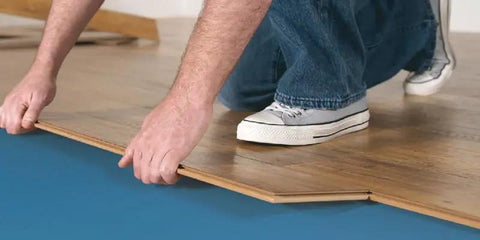Person installing Top Tier Floating Floor Underlayment 200 Square Foot Roll with 3Mm Density under laminate flooring.