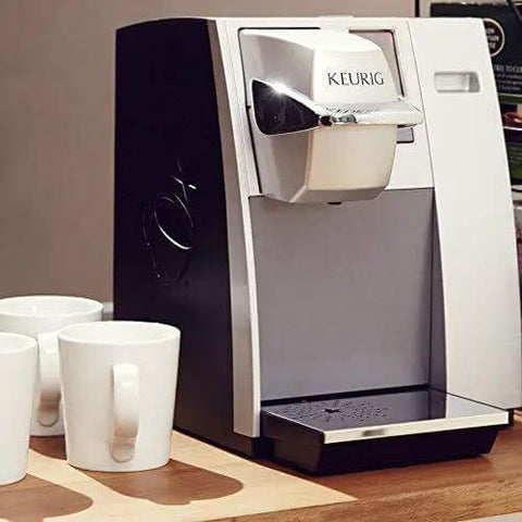 Office Pro Style Commercial Single Cup Coffee Maker With K Cup Pod Compatible, colorful touchscreen, on countertop, mugs beside.