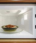 10 Piece Microwave Oven Mica Insulation Sheets Heat Resistant Waveguide Cover Plates installed in a microwave with a dish inside.