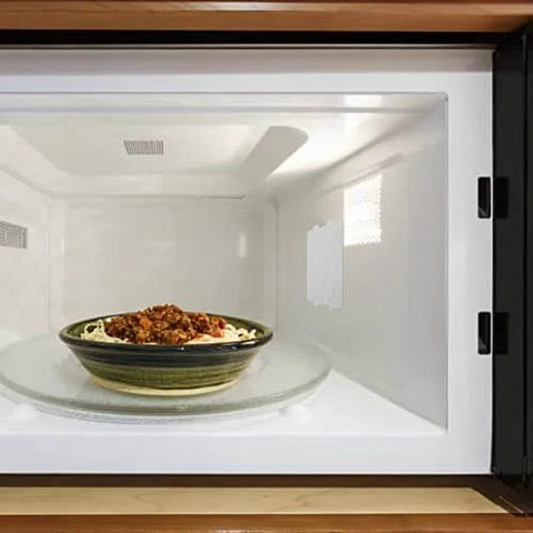 10 Piece Microwave Oven Mica Insulation Sheets Heat Resistant Waveguide Cover Plates installed in a microwave with a dish inside.