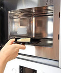 Person placing food in microwave, highlighting the use of 10 Piece Microwave Oven Mica Insulation Sheets Heat Resistant Waveguide Cover Plates Durable Mica Material For Kitchen Use Easy To Cut To Fit Slots And Grooves Ideal Microwave Accessory For Safe Long Lasting Performance