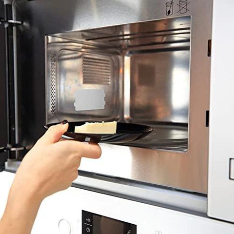 Person placing food in microwave, highlighting the use of 10 Piece Microwave Oven Mica Insulation Sheets Heat Resistant Waveguide Cover Plates Durable Mica Material For Kitchen Use Easy To Cut To Fit Slots And Grooves Ideal Microwave Accessory For Safe Long Lasting Performance