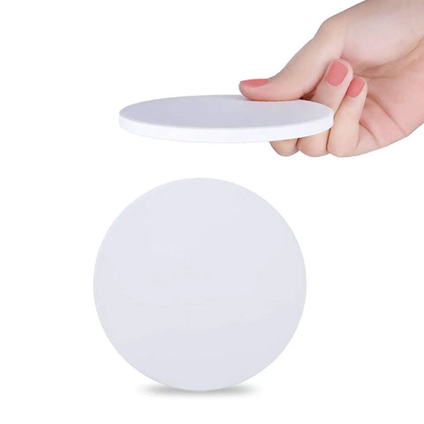Hand holding 144 Pcs Round Coaster Blanks 4.25 Inch Ceramic Tiles With Cork Backing, Sublimation Blanks for DIY projects