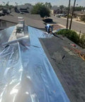 Four By Two Hundred Fifty Foot Synthetic Roof Underlayment Pro Grade Heavy Slick Roll installed on a sloped roof by a worker.