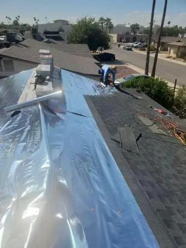Four By Two Hundred Fifty Foot Synthetic Roof Underlayment Pro Grade Heavy Slick Roll installed on a sloped roof by a worker.