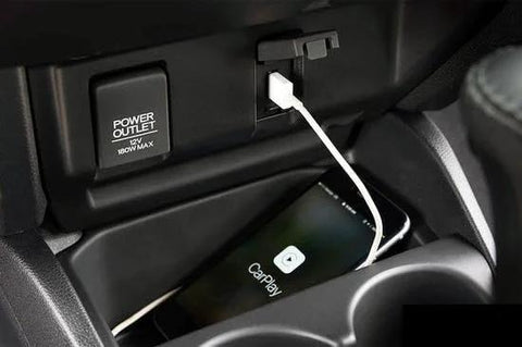CarPlay USB-C charging cable (white) connected to car USB port with iPhone displaying CarPlay