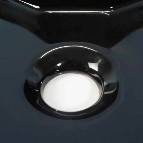 Close-up of USZWBY Vessel Sinks Bathroom Vessel Sink with Faucet Hole, glossy black ceramic surface and round drain opening.