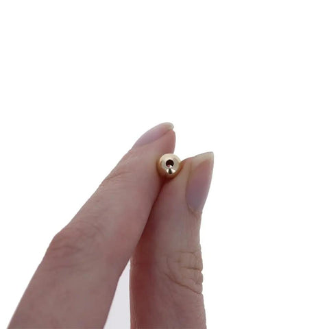 Straight Premium 6MM Gold Filled Round Beads For Jewelry Crafting, showing hand holding a bead with 1.5mm hole.