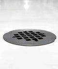 Heavy Duty No Caulk Shower Drain With Slick Polished Chrome Grate, 4.5in diameter grate on white surface.