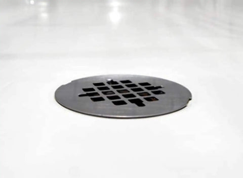 Heavy Duty No Caulk Shower Drain With Slick Polished Chrome Grate, 4.5in diameter grate on white surface.