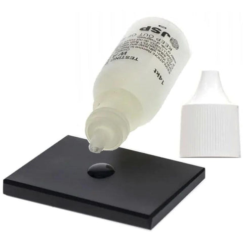 Waytest silver testing solution bottle; white dropper bottle with liquid on black testing tile