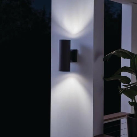 12 Inch Cylindrical Outdoor Wall Sconce In Black With Dual Up And Down Ambient Lighting on porch at night