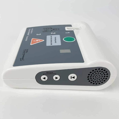 AED training device front-side view: Practi-Trainer base unit with gray control panel and speaker grille.