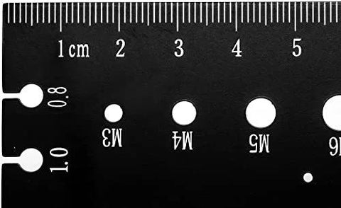 Thread pitch gauge, black metal with metric scale and M3, M4, M5 holes (close-up)