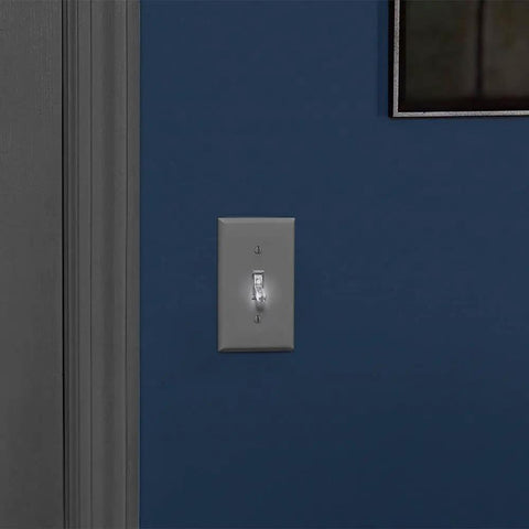 15 Amp Toggle LED Illuminated Single Pole Switch L1461-2C Clear Finish installed on a blue wall, glowing white in the off position