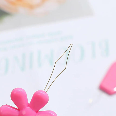 Close-up of a pink petal-shaped needle threader from 40 Piece Dope Petal Shaped Needle Threader Set In Assorted Colors For Hand Sewing, Cross Stitch, And Clothes Repair, Colorful Threader Kit For Mending, Jewelry Making, Quick Threading And Easy Craft Projects.