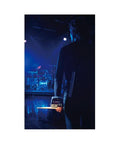 Musician holding Compact Acoustic Drum Trigger Module With 162 Ready To Play Pro Sounds, facing a stage setup.