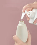 Filling a bottle from the Grab And Go Leak Proof Travel Bottle Set Of 3 60 Ml Refillable Squeezable Containers.
